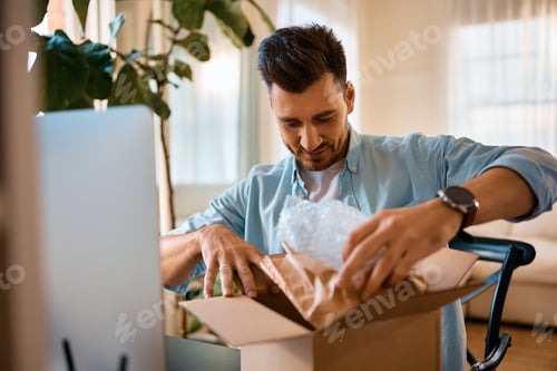 Preview: Happy man unboxing home delivered package.