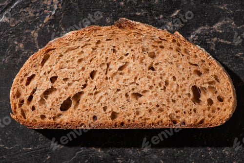 Preview: Top View of Brown Bread Slice on Stone Black Surface