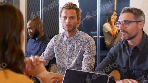 Preview: Business Team Having Informal Meeting Sitting Around Table In Modern Office Together