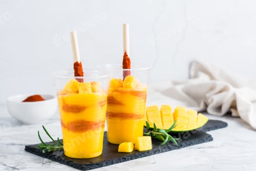 Preview: Mangonada drink made from mango and tajin chili powder in plastic glasses. Mexican cuisine