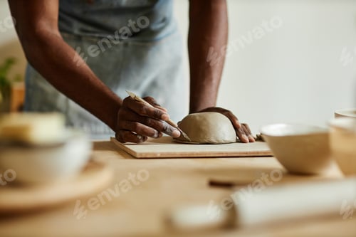 Preview: Male artist creating handmade ceramic bowl in cozy pottery studio