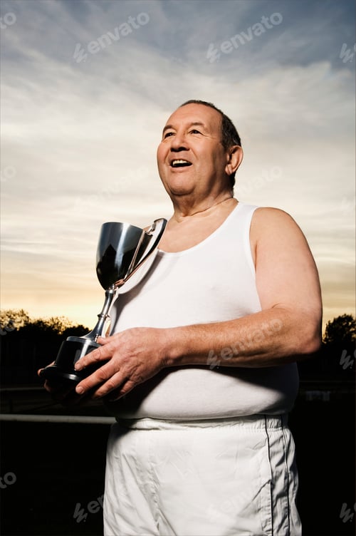 Preview: Smiling elderly men in sportswear, holding a silver trophy.