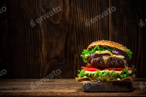 Preview: Tasty Big Burger in Bun on Wooden Background with Copy Space