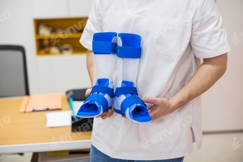Preview: Doctor holding orthopedic ankle foot braces