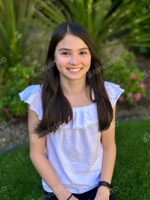Preview: Biracial tween girl smiling for portrait with green background.