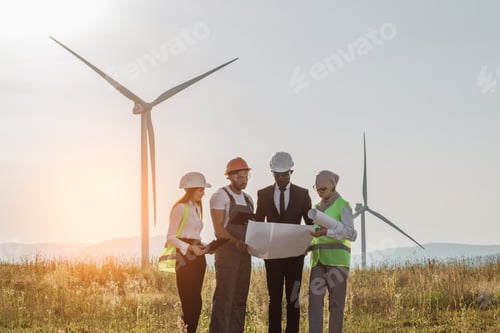 Preview: Multi ethnic group people having meeting on windmill farm