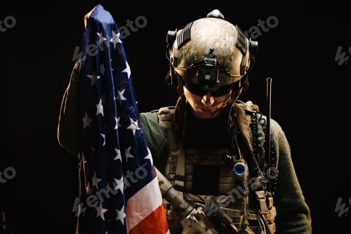Preview: Special forces soldier holding US national flag in the dark