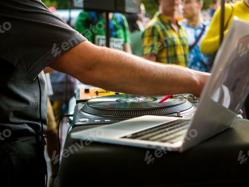 Preview: close up hand adjusting music settings on the laptop computer