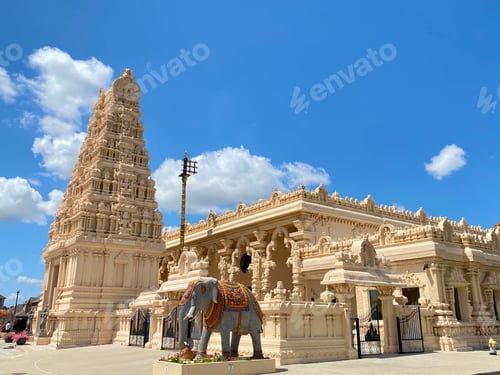 Preview: Beautifully detailed Hindu temple with a clear blue sky and a statue of an elephant in front