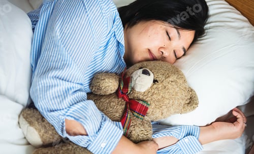 Preview: A woman in bed with a teddy bear