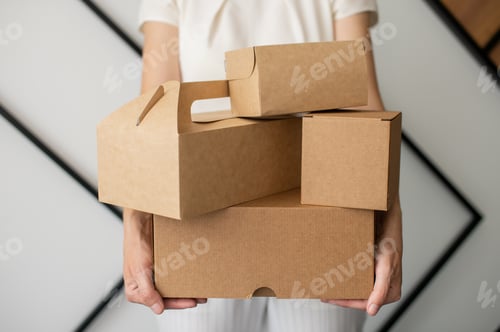 Preview: A set of craft boxes and packages in the hands of a person without a face