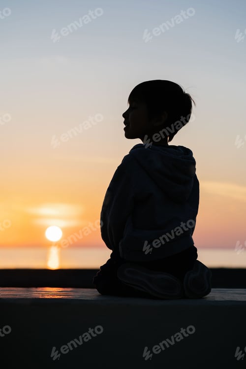 Preview: Beautiful sunset on the sea with the silhouette of a child on the backgroun