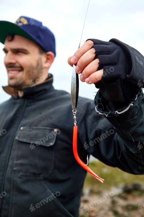 Preview: Young man holding fishing line and hook