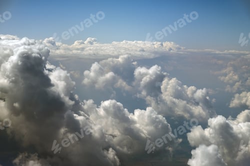 Preview: Aerial view from airplane window of white puffy clouds on bright sunny day