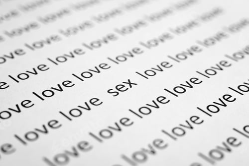 Preview: Diagonally printed words love and sex on white paper, close-up. Low angle view, macro photo