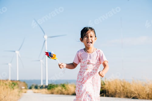 Preview: Child's playful exploration by windmills, little girl runs with pinwheels
