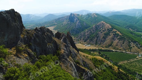 Preview: Top view of a mountainous area with a settlement on a summer day. Shot. Private houses in a village