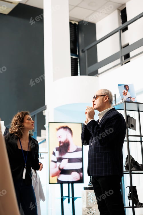 Preview: Showroom manager helping senior shopper