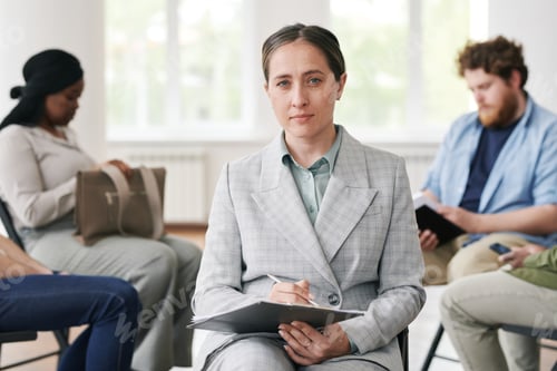 Preview: Young confident female counselor in elegant grey suit holding document