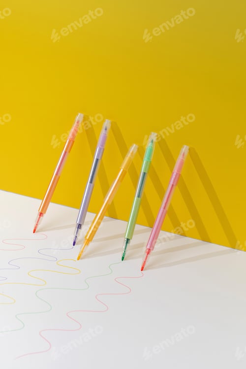 Preview: Colored markers stand against a yellow background. Art concept, stationery concept.