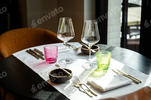 Preview: Sophisticated table with colorful glassware. Upscale restaurant decor with elegant table settings