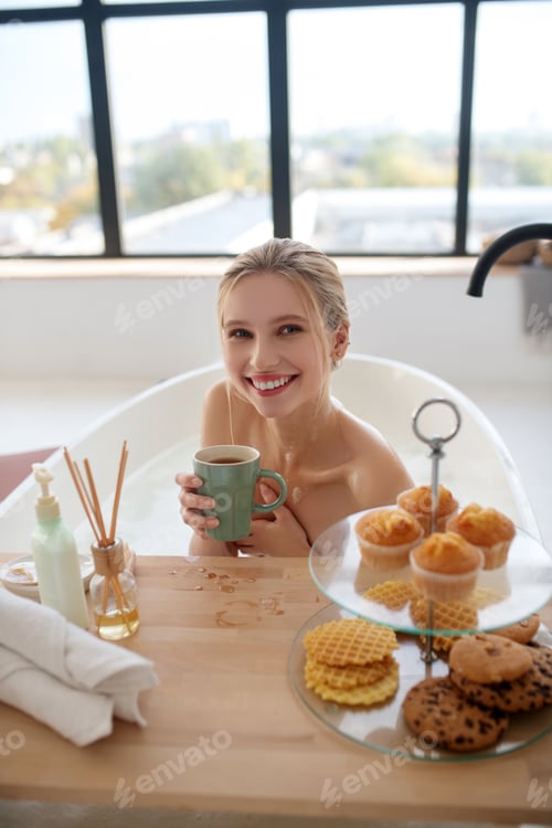 Preview: Smiling happy woman having perfect breakfast in bath