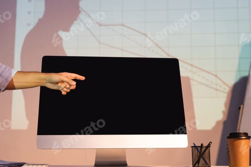 Preview: cropped view of businessman pointing with finger at computer monitor with blank screen