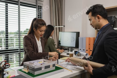 Preview: an architect is working in the office with his team, blueprint on the desk, contractor working with