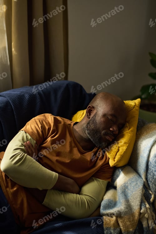 Preview: Resting African American Man On Cozy Sofa Under Blanket