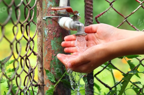 Preview: Close up child hands with water drops from old grunge brass faucet