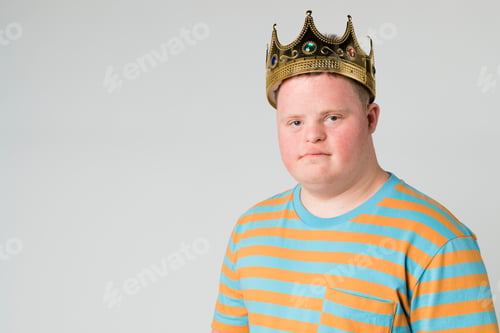 Preview: Confident boy with down syndrome wearing a crown
