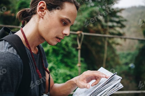 Preview: Caucasian man looking at a map travel and explore concept