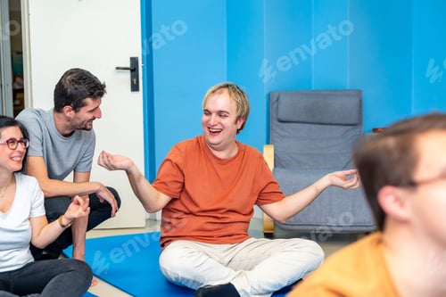Preview: Instructor and disabled man smiling during yoga class