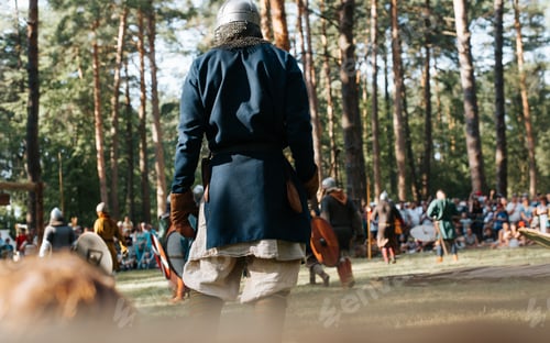 Preview: Costumed reconstruction of medieval battle in open air. Back view of viking warrior
