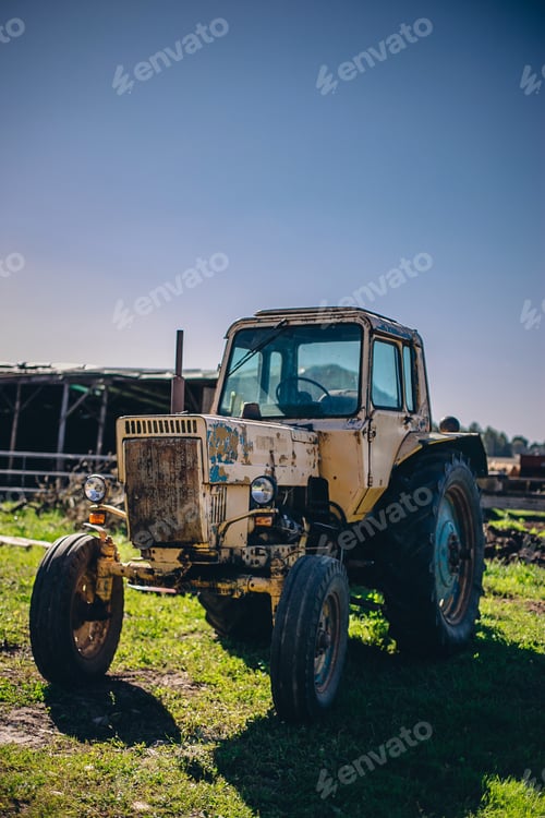 Preview: Vertical shot of an old tractor in the field in a rural area