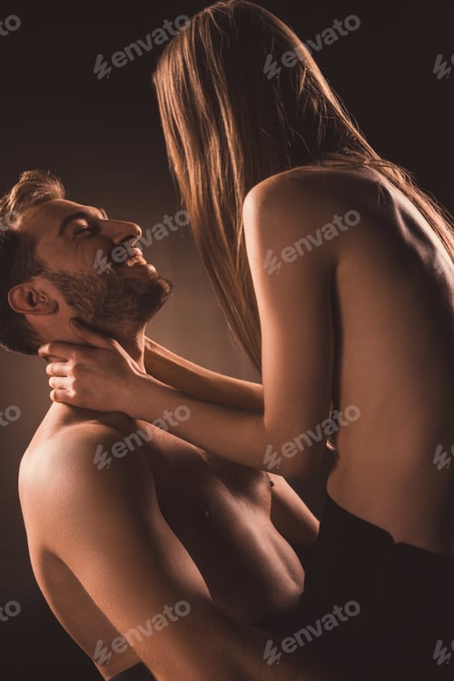 Preview: passionate couple hugging and looking at each other, on brown
