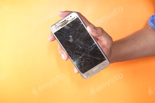 Preview: Close up of man hand holding broken smart phone.