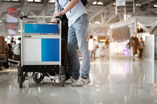 Preview: Travelers are walking to drag luggage in modern airport terminal to travel to new places. Rear view.