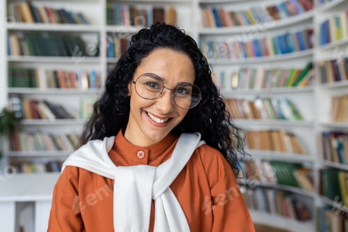 Preview: Portrait of young beautiful female student inside university academic library, Hispanic woman with