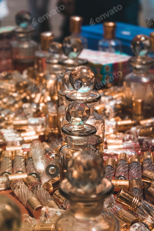 Preview: Vertical shot of vintage old-fashioned containers for a perfume made of glass.