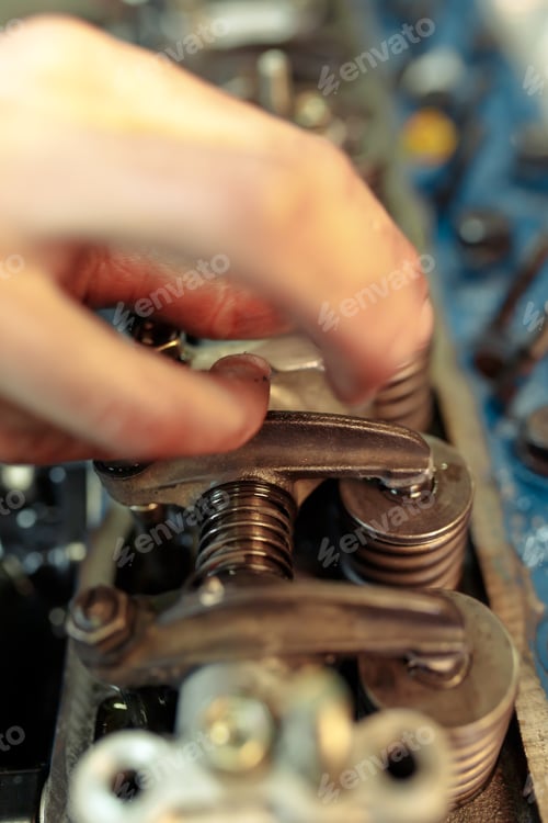 Preview: Vertical closeup shot of a mechanic mounting the car engine