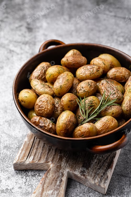 Preview: Pan filled with roasted potatoes shot on rustic wooden table.