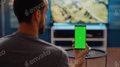 Preview: Person with modern smartphone looking at green screen