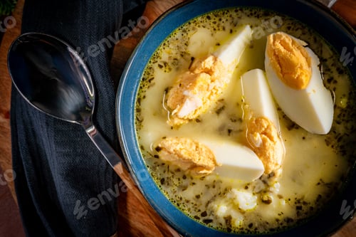 Preview: A bowl of soup sorrel with rice and boiled egg.