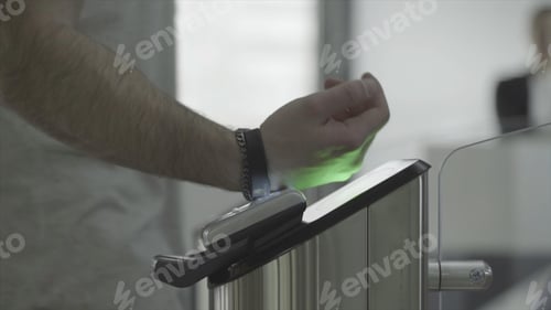 Preview: Man applying RFID bracelet to the electronic access equipment on entrance gate to the subway