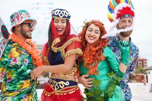 Preview: Happy dressed people celebrating at carnival party dancing together - Main focus on right woman face