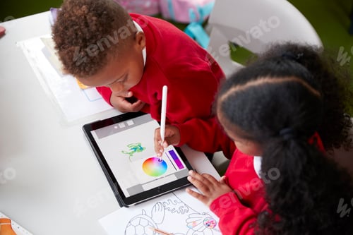 Preview: Two kindergarten school kids sitting at a desk in a classroom drawing with a tablet computer