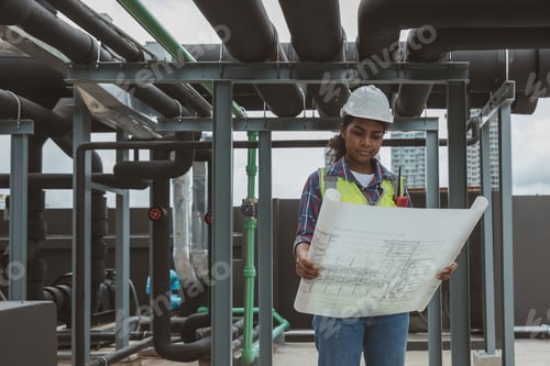 Preview: Engineers with draft plan of building on constructing site.