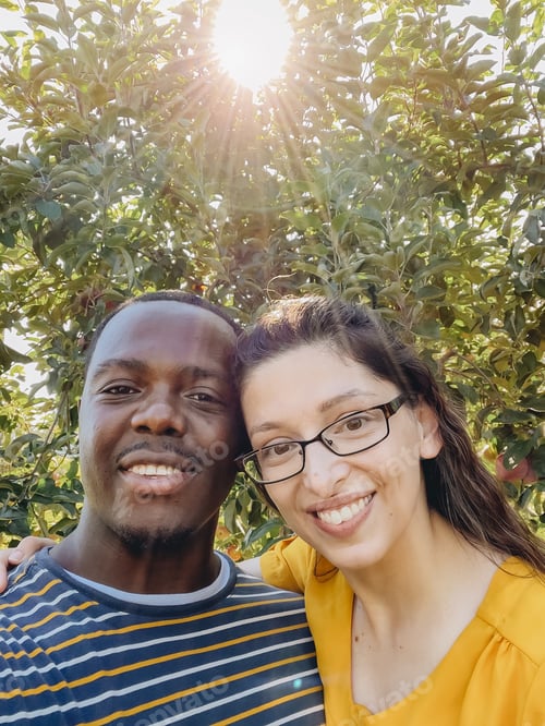 Preview: Couple taking selfie outdoors under the glow of sunset