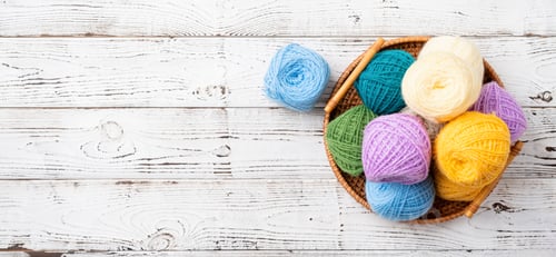 Preview: bright colorful yarn wool in a basket on wooden background